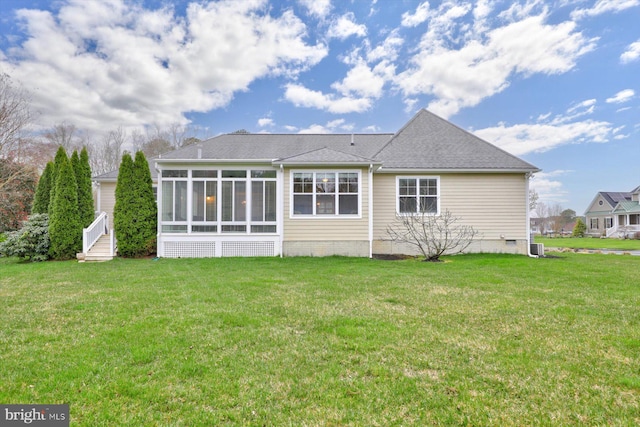 rear view of property featuring a yard and a sunroom