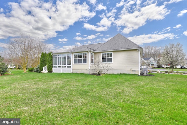 rear view of house featuring a sunroom and a yard