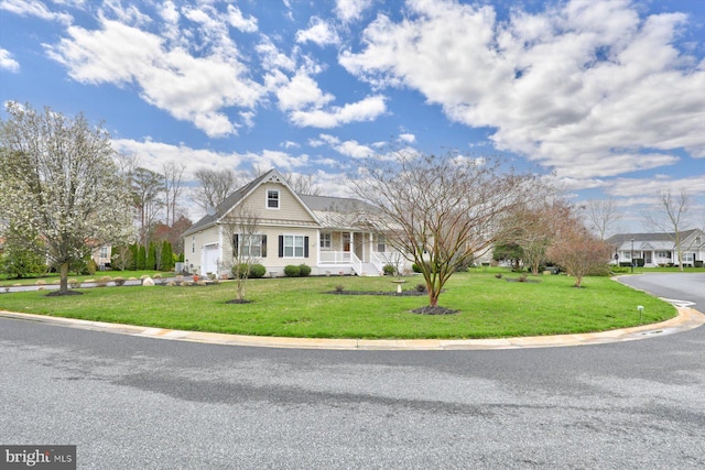 view of front of house with covered porch, a garage, and a front lawn