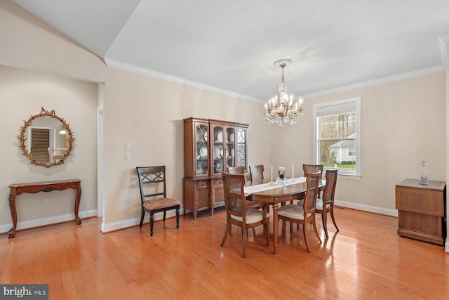 dining space featuring a notable chandelier, light hardwood / wood-style floors, and ornamental molding