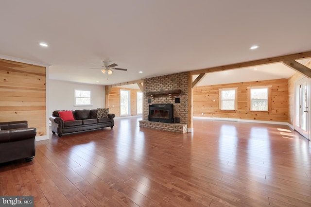 living room with a fireplace, dark wood-type flooring, and a wealth of natural light