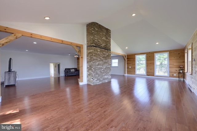 unfurnished living room with high vaulted ceiling, wooden walls, and dark wood-type flooring