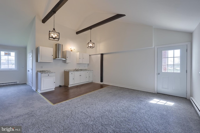 kitchen featuring dark carpet, white cabinetry, wall chimney range hood, hanging light fixtures, and beam ceiling