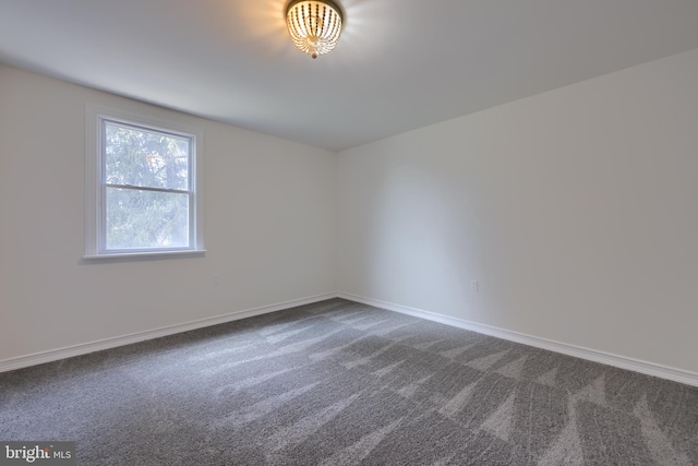 unfurnished room featuring dark carpet