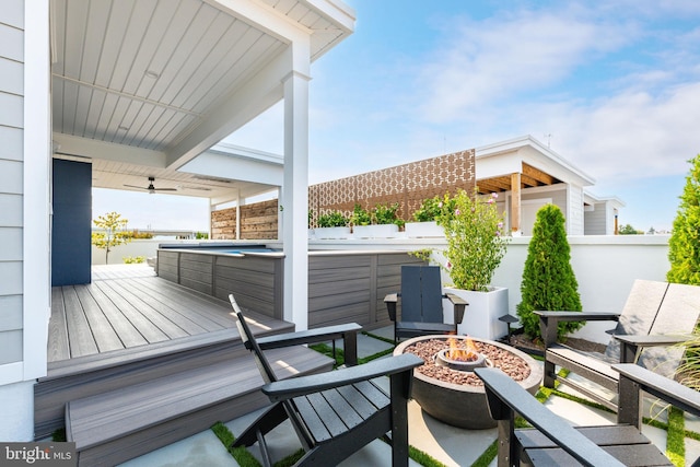 exterior space with a fire pit and a hot tub