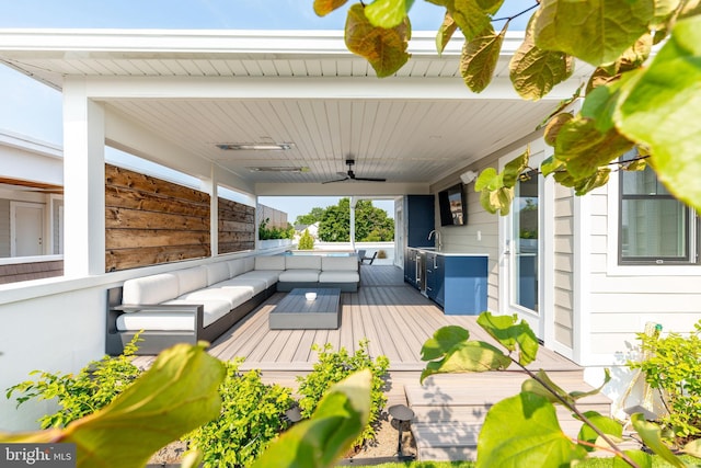 wooden deck with an outdoor living space, ceiling fan, and a sink