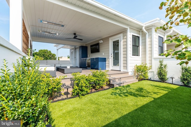 exterior space with a lawn and ceiling fan