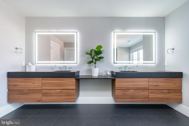 bathroom featuring tile patterned flooring, two vanities, and a sink