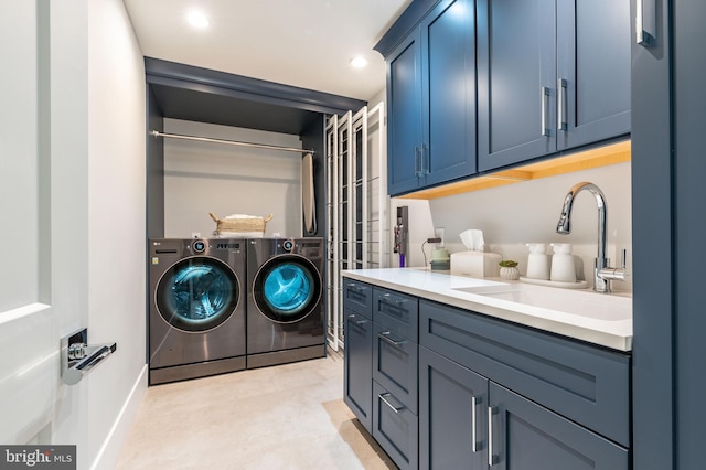 washroom featuring recessed lighting, washing machine and dryer, baseboards, and a sink