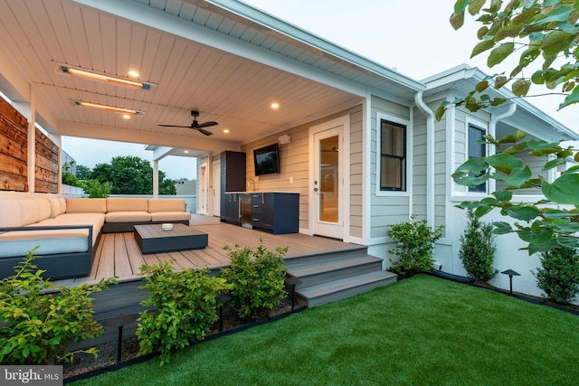 wooden terrace featuring outdoor lounge area, ceiling fan, and a lawn