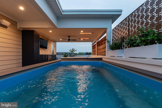 view of pool with an outdoor kitchen, ceiling fan, and a hot tub