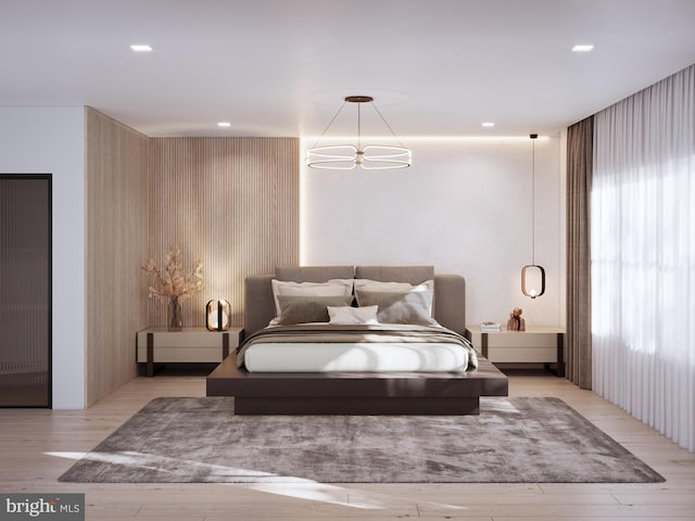 bedroom featuring recessed lighting, an inviting chandelier, and wood finished floors