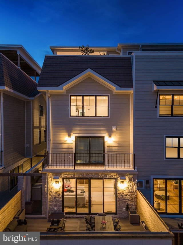 back of property with a balcony