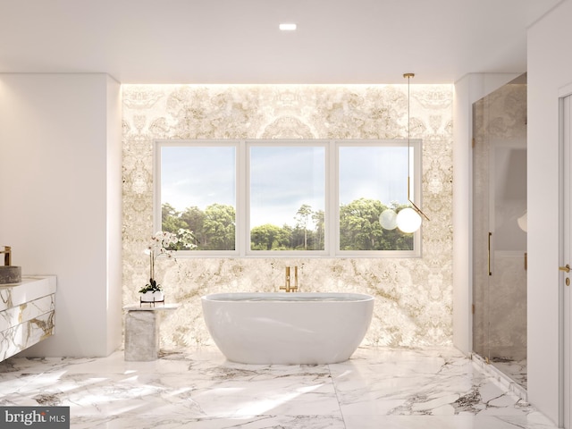 bathroom with marble finish floor and a freestanding tub