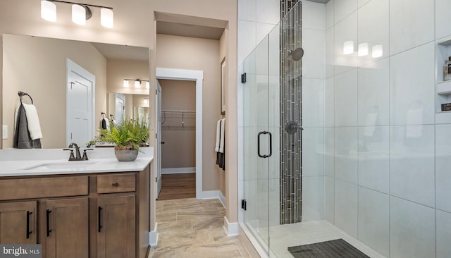 bathroom with tile flooring, a shower with shower door, and vanity with extensive cabinet space