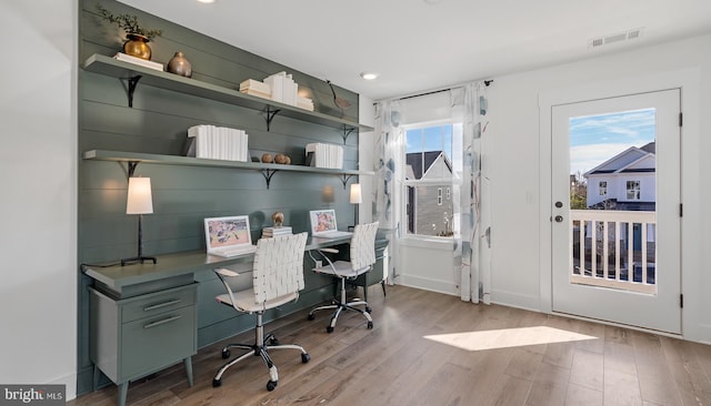 office space with light hardwood / wood-style floors and a healthy amount of sunlight