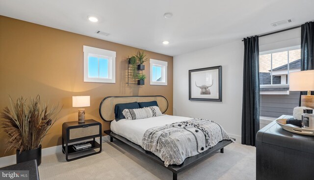 bedroom featuring multiple windows and light carpet