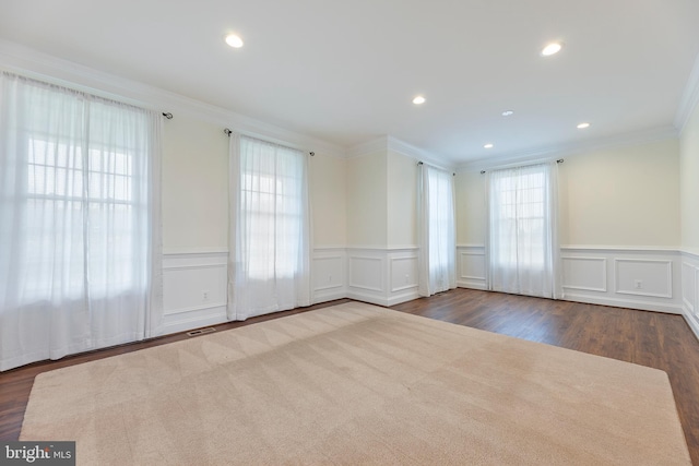 spare room with plenty of natural light, dark hardwood / wood-style floors, and crown molding