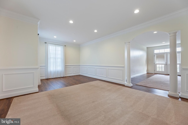 empty room featuring ornamental molding, a healthy amount of sunlight, and dark wood-type flooring