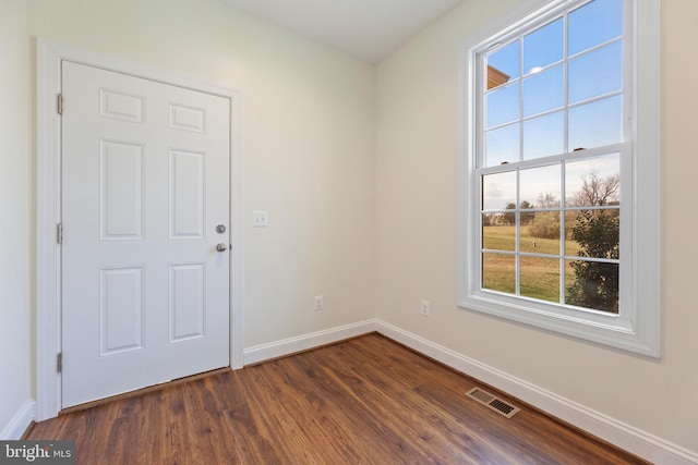 empty room with dark hardwood / wood-style flooring