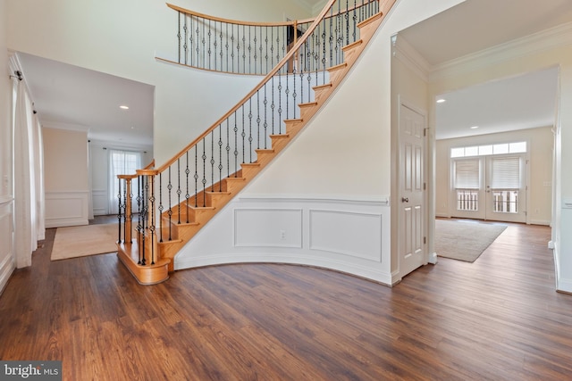 stairway featuring plenty of natural light, hardwood / wood-style floors, and crown molding