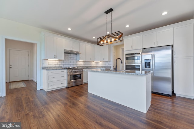 kitchen with light stone counters, hanging light fixtures, dark hardwood / wood-style flooring, stainless steel appliances, and white cabinetry