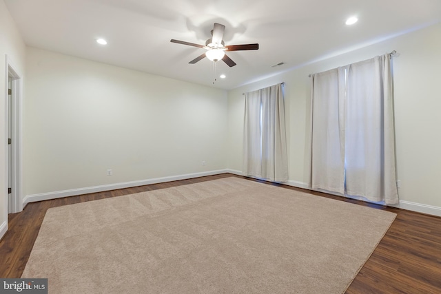 spare room with dark hardwood / wood-style flooring and ceiling fan