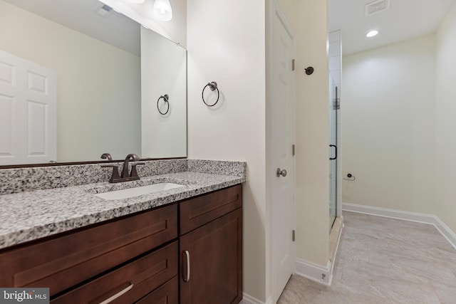 bathroom with vanity, a shower with door, and tile flooring