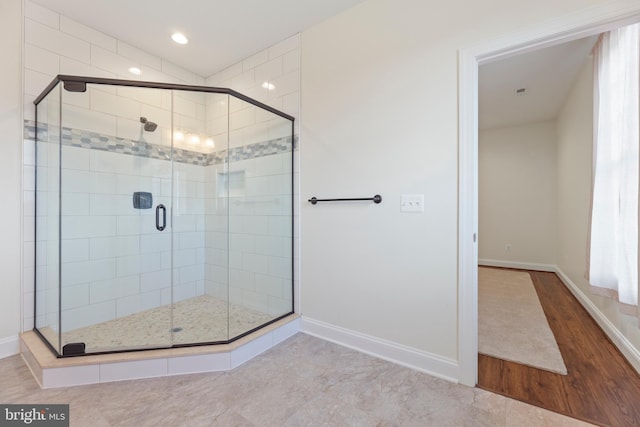 bathroom with a shower with door and hardwood / wood-style flooring