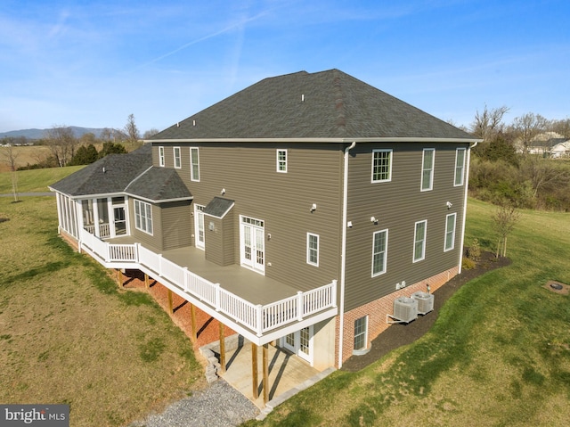 rear view of property featuring a wooden deck, central AC unit, and a yard