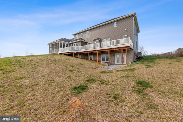 back of property with a yard, french doors, and a wooden deck