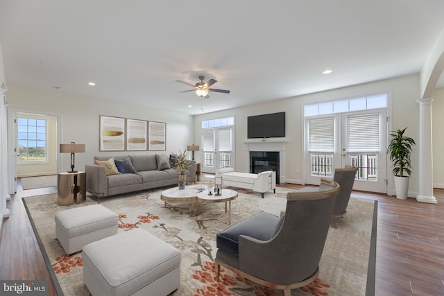 living room with french doors, decorative columns, wood-type flooring, and ceiling fan