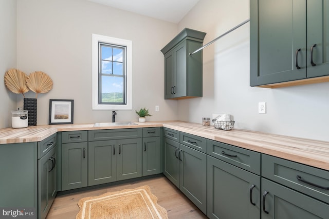 kitchen featuring light wood-type flooring, wood counters, and a sink