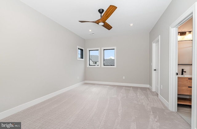 unfurnished bedroom featuring a sink, recessed lighting, baseboards, and light carpet