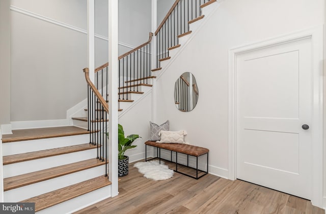 staircase with wood finished floors and baseboards