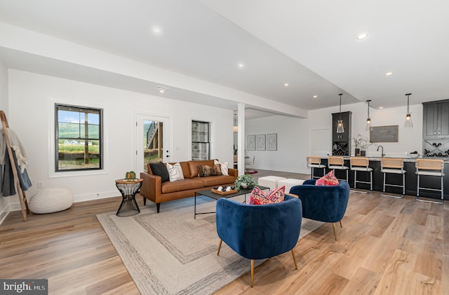 living room with recessed lighting, baseboards, and light wood finished floors