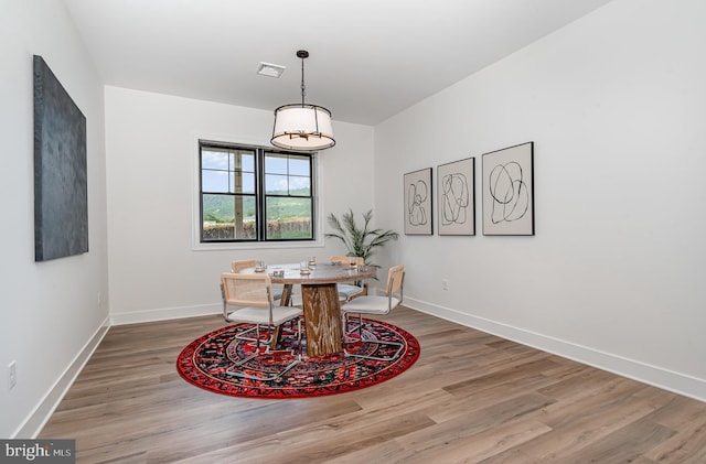 dining room featuring visible vents, baseboards, and wood finished floors