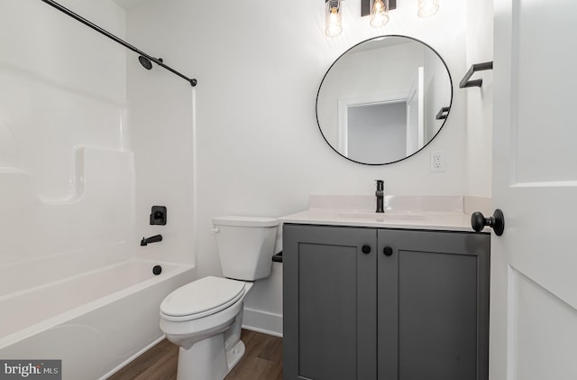 full bathroom with vanity, wood finished floors, baseboards, bathtub / shower combination, and toilet