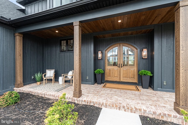 property entrance with a porch, board and batten siding, and a shingled roof