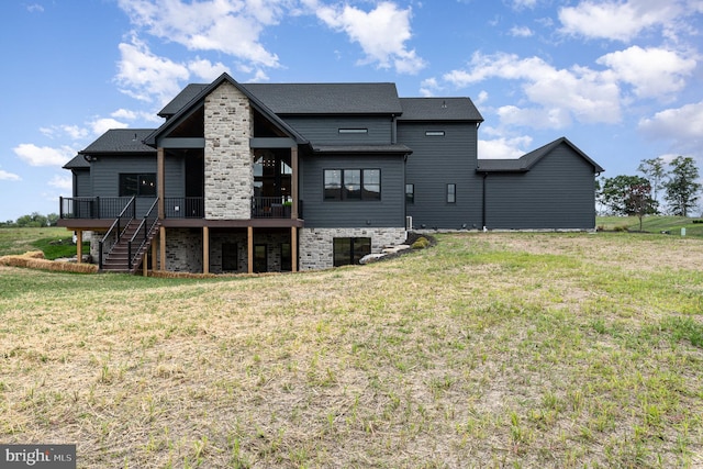 back of property with a deck, stairway, and a lawn