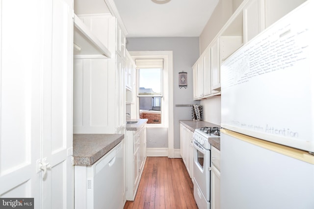 kitchen with dark hardwood / wood-style floors, white appliances, and white cabinetry