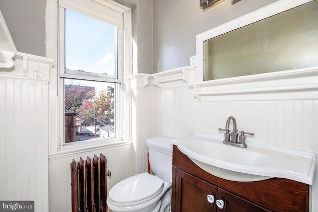 bathroom with vanity, radiator, and toilet