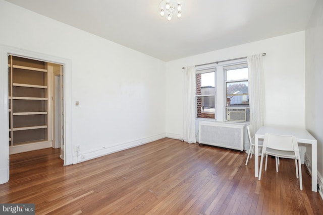 interior space with wood-type flooring and radiator heating unit