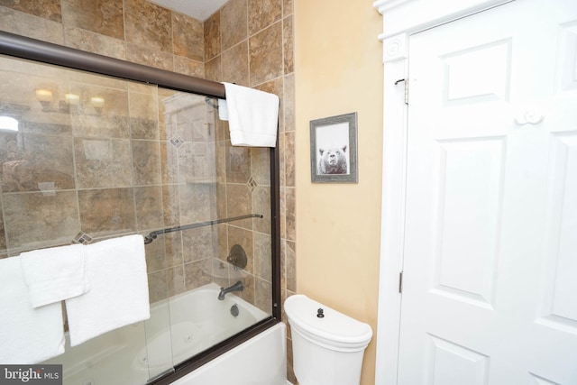 bathroom with shower / bath combination with glass door and toilet