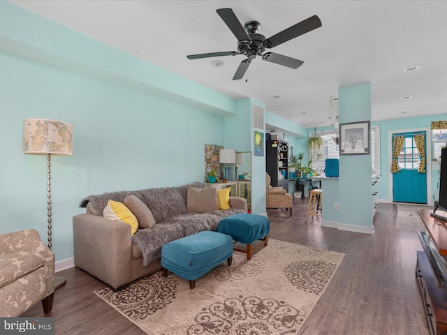 living room with dark hardwood / wood-style flooring and ceiling fan