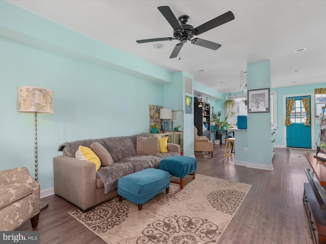 living room featuring ceiling fan and dark hardwood / wood-style flooring