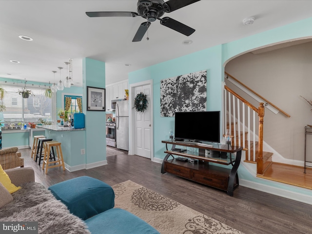 living room with ceiling fan and dark wood-type flooring