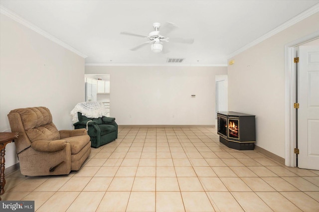 living room featuring ceiling fan, a wood stove, ornamental molding, and light tile floors