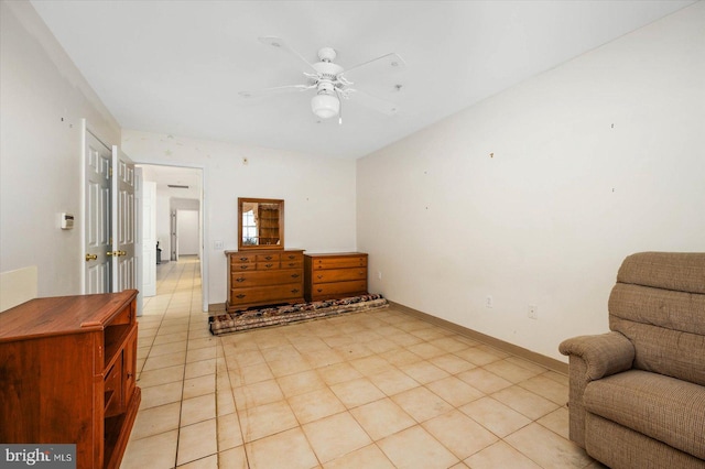 living area featuring light tile floors and ceiling fan