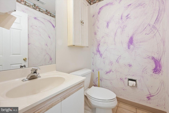 bathroom with toilet, vanity, and tile flooring